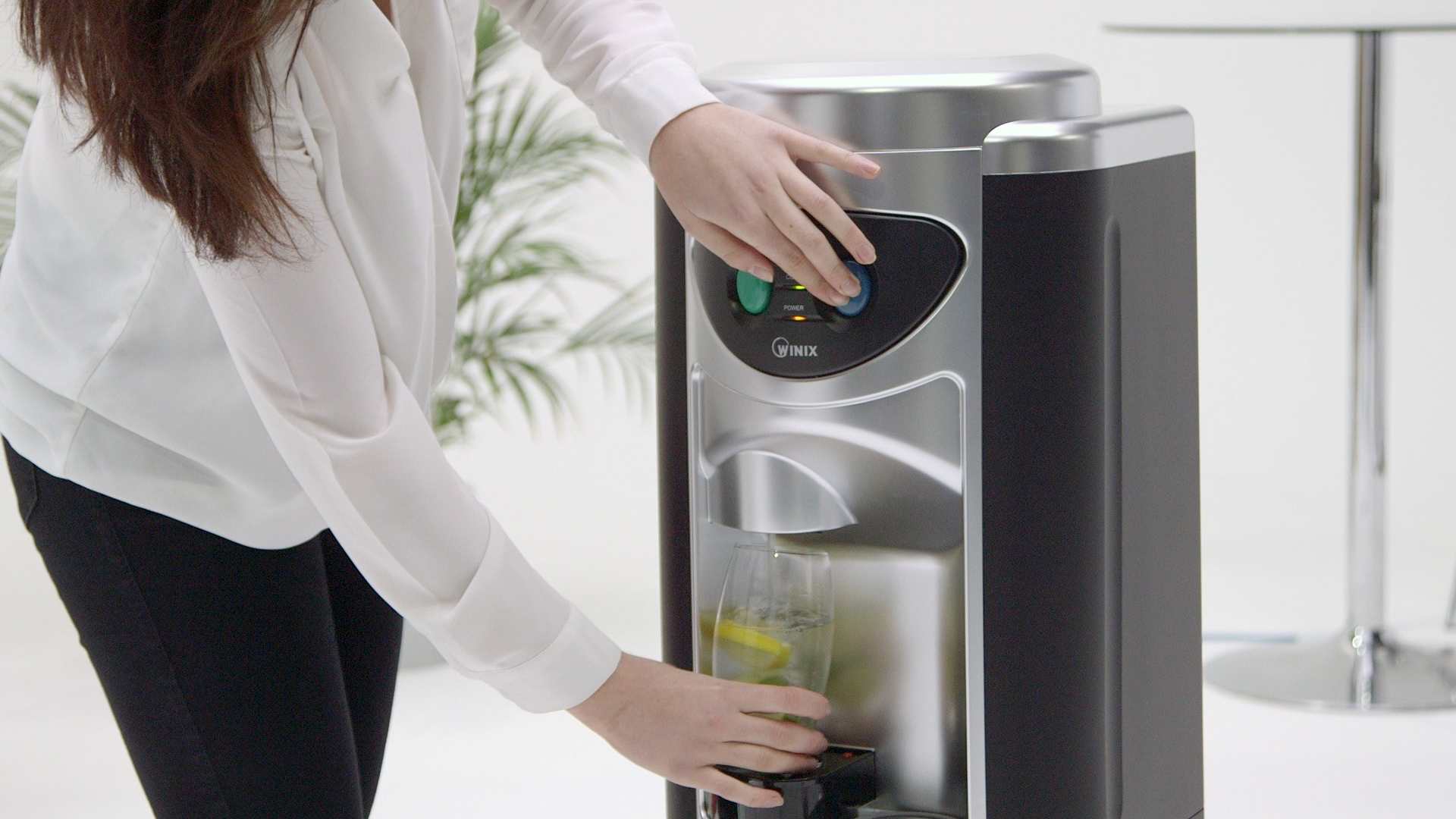 Woman filling glass from water cooler